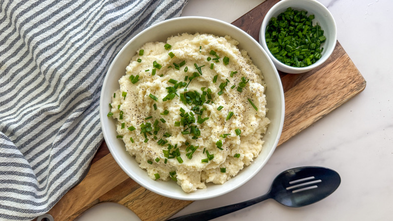 Cauliflower mash in bowl garnished with chives
