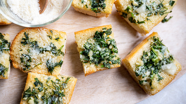 Garlic bread slices on wooden board