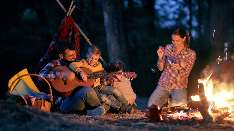 Family camping around fire