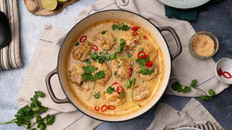 Coconut and Lime Chicken Thighs in Dutch oven on kitchen towel