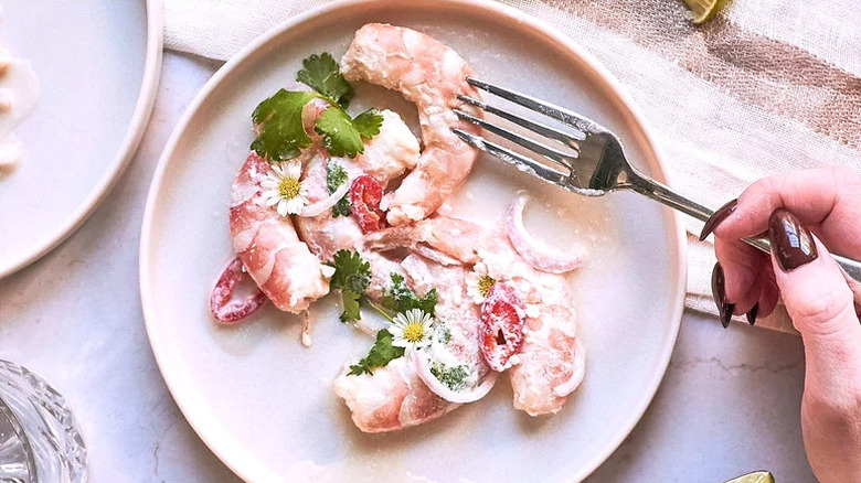 Coconut-Lime Ceviche on white plate with edible flowers