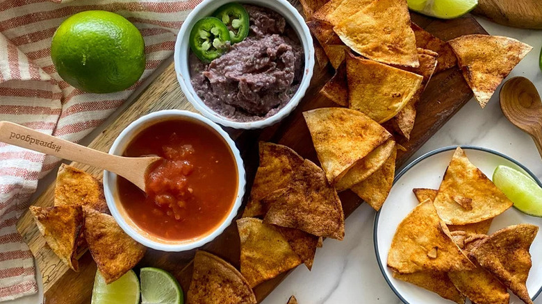 Homemade Chili Lime Tortilla Chips on wooden board with two dips