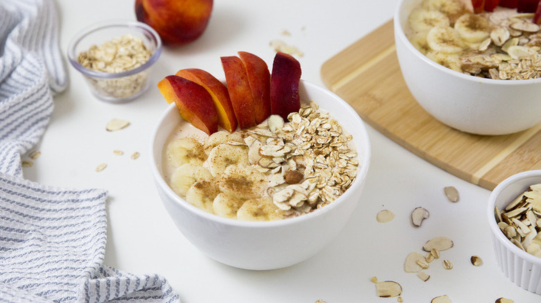 Smoothie bowls topped with sliced peaches and bananas