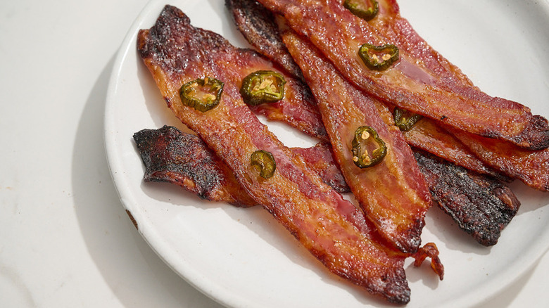 Spicy crispy bacon strips on plate