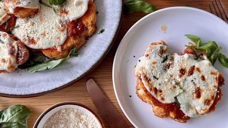 Cauliflower Parmesan served onto plate and sprinkled with grated Parmesan