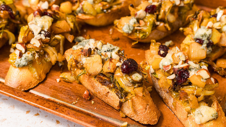 Pear, Brussels sprouts, and Gorgonzola bruschettas on wooden board