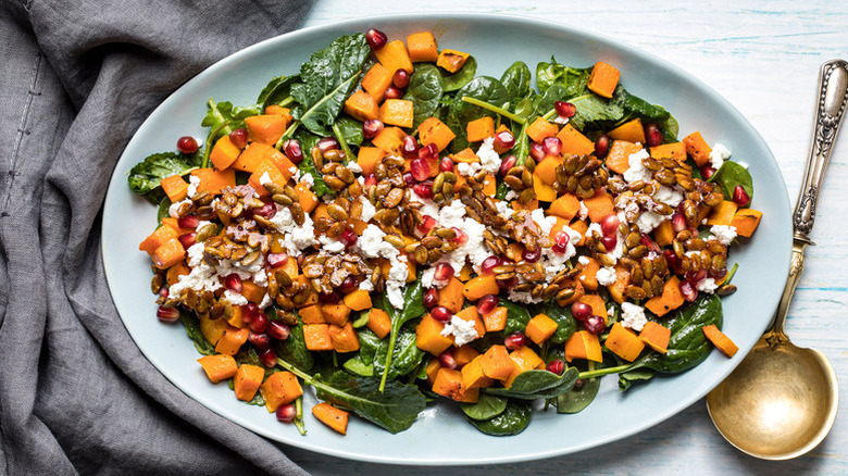 Roasted butternut squash, spinach, and feta salad on serving platter
