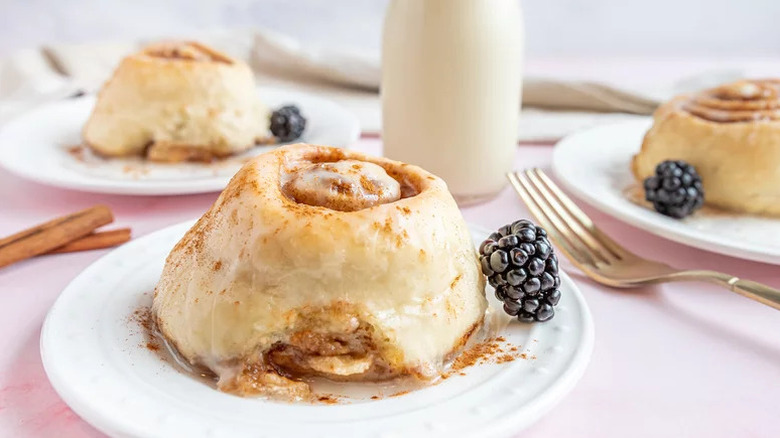 Vegan Cinnamon Rolls on white plates with blackerries
