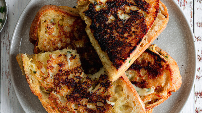 Sliced grilled cheese sandwiches piled onto plate