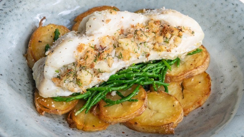 Baked stuffed haddock on bed of greens and crispy sliced potatoes.
