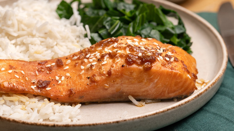 Soy and ginger baked salmon on plate with rice and greens.