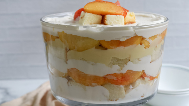 Peaches and cream trifle in a glass dessert bowl