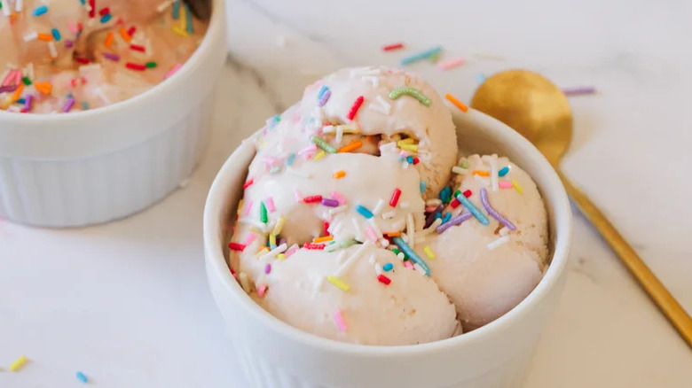 Birthday Cake Batter Ice Cream in white dishes with gold spoon