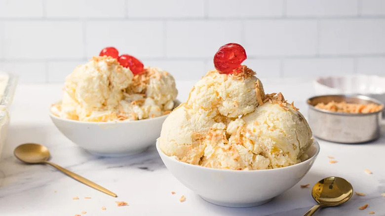 Caramelized Pineapple Ice Cream in white bowls with cherries on top