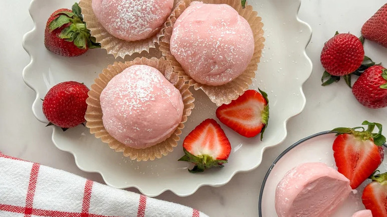 Mochi Ice Cream That's Bursting with Strawberry Flavor on white plate with strawberries