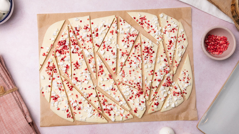 Sliced white chocolate and raspberry bark on piece of parchment paper