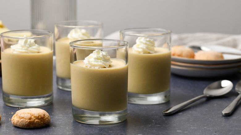 White chocolate mousse in dessert glasses, each topped with swirl of whipped cream