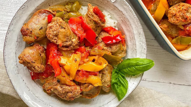 Easy Instant Pot Sausage and Peppers in grey bowl with sprig of basil