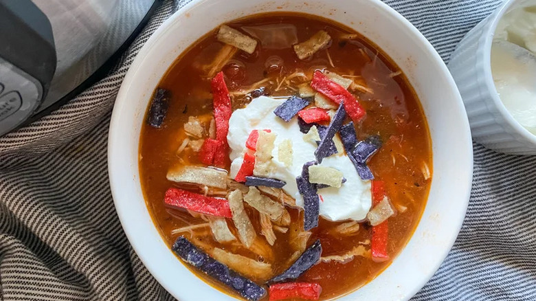 Instant Pot Chicken Tortilla Soup in white bowl on striped towel