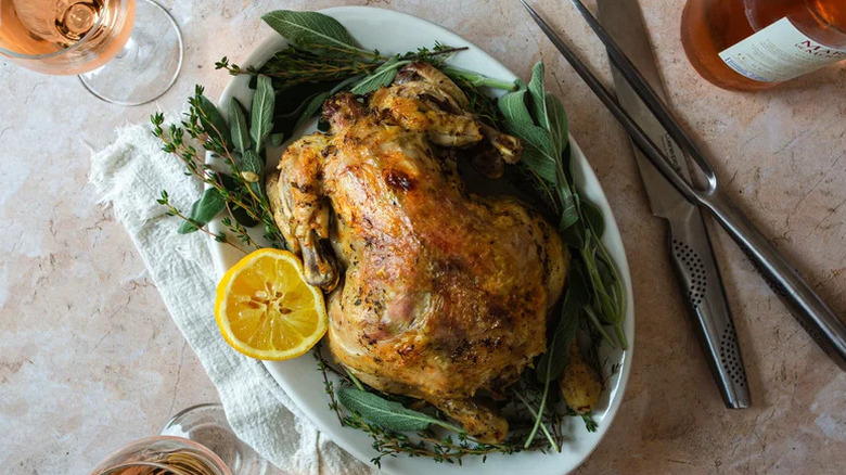 Instant Pot Classic Whole-Roasted Chicken on platter with orange half and herbs