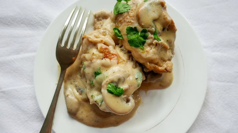 Instant Pot Creamy Garlic Chicken on white plate with fork