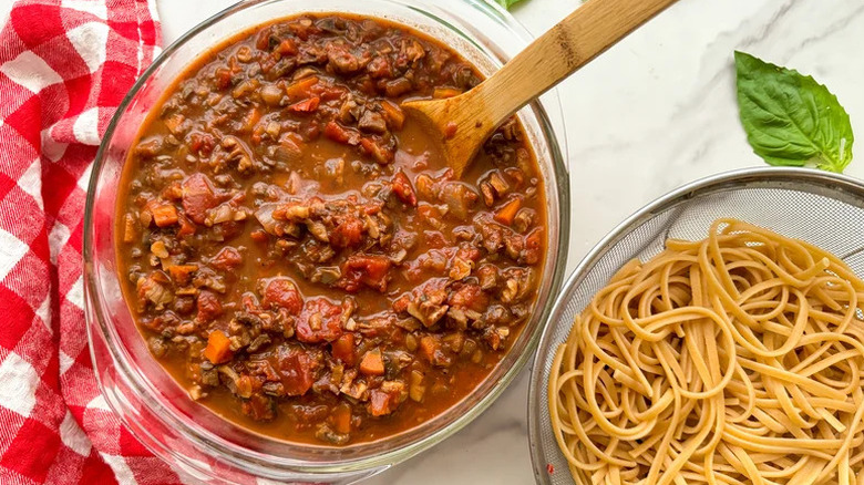 Instant Pot Mushroom Bolognese in large glass bowl with strainer of pasta