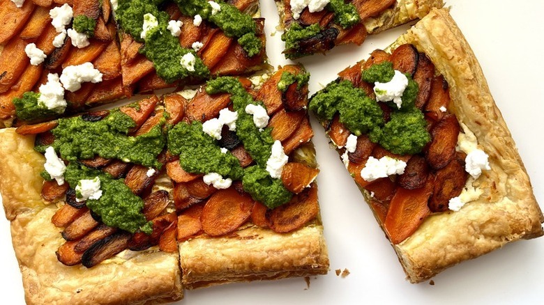 Carrot and goat cheese puffy pastry tart topped with pesto