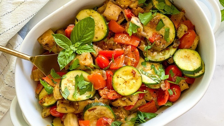 Ratatouille in white baking dish with fresh basil