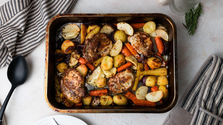 Baked pork chops in roasting tin with root veggies and apples