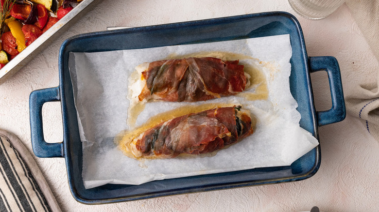 Parma ham-wrapped monkfish in blue baking dish