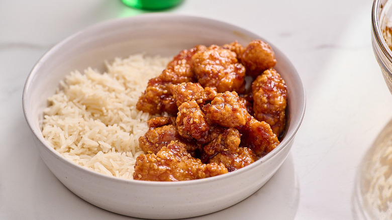 Crispy orange chicken in bowl with rice