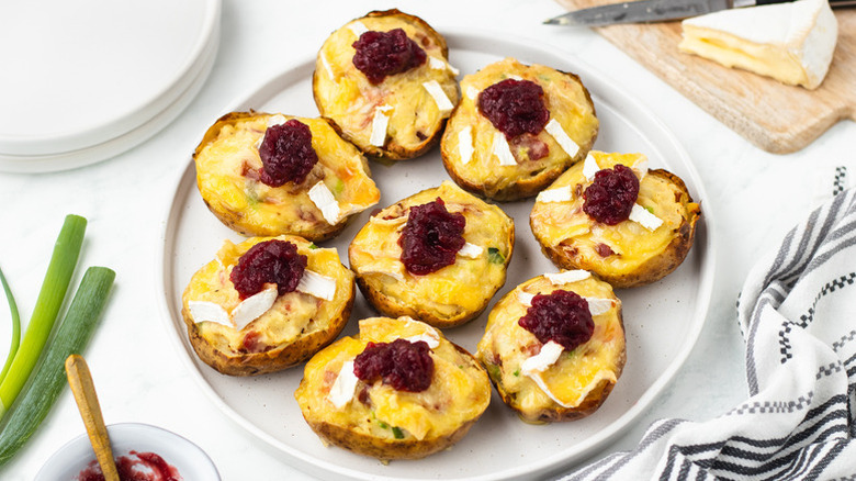Brie and bacon potato skins on plate, topped with cranberry sauce