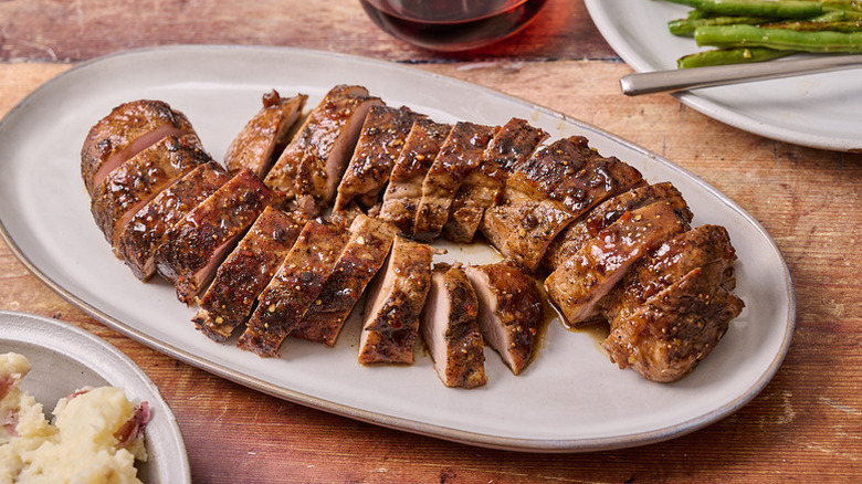Glazed, sliced pork tenderloin on serving platter