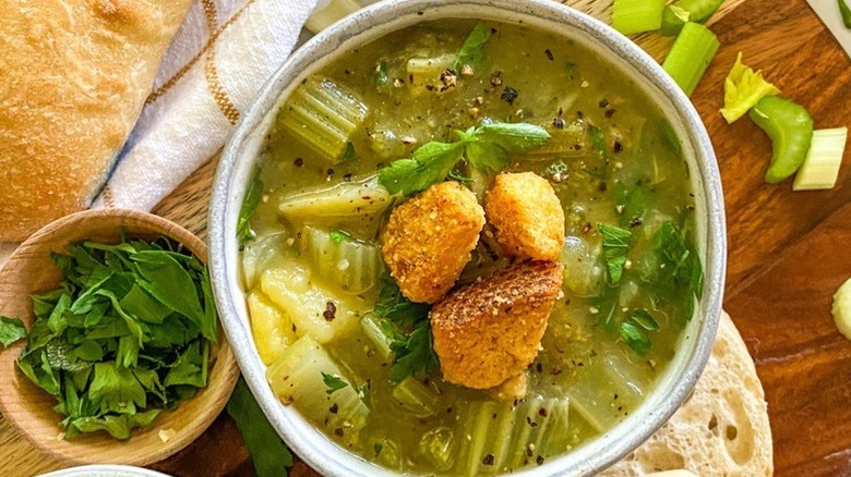 Bowl of celery soup topped with crispy croutons