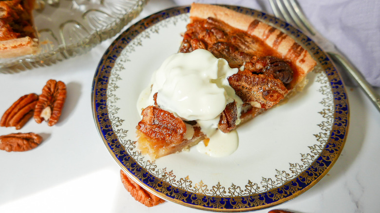 pecan pie with cream on plate