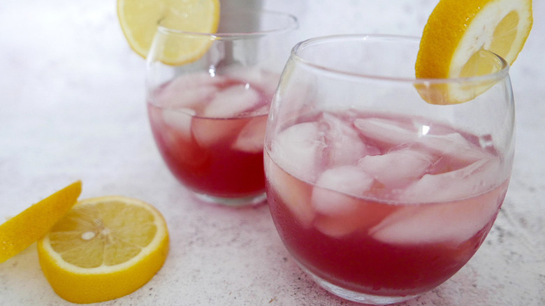 Belmont jewel cocktails in glasses with ice, each garnished with a lemon round
