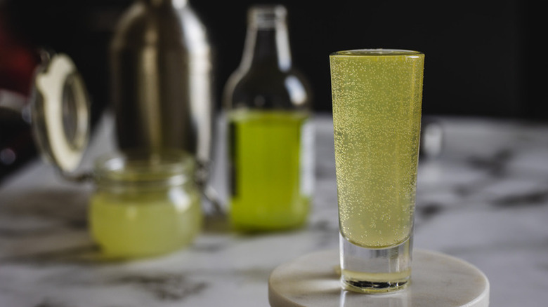 Fizzy green tea cocktail in shot glass