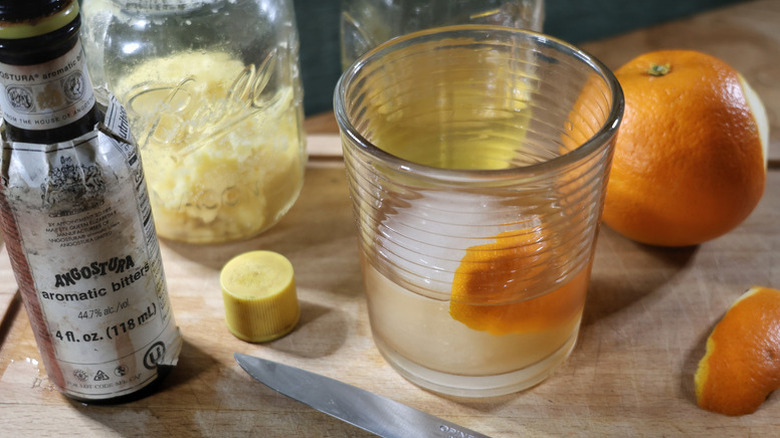 Butter-washed old fashioned cocktail in glass with orange peel and ice