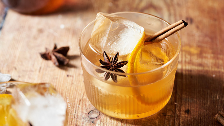 Spiced chai old fashioned cocktail in glass with cinnamon stick and star anise pod