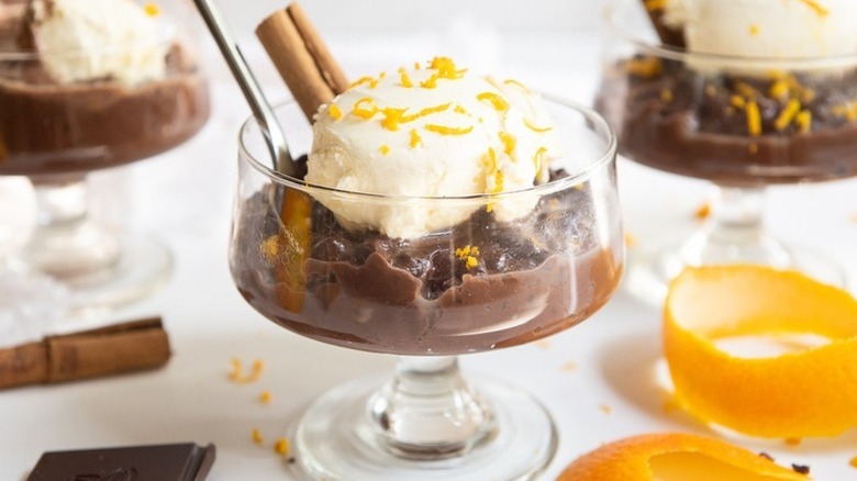 Chocolate orange risotto in dessert glasses, topped with whipped cream and orange zest