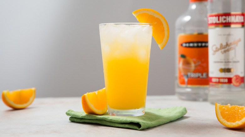 Orange crush cocktail in glass with crushed ice, garnished with orange slice
