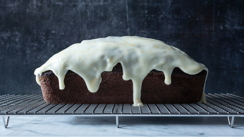 Glazed chocolate orange loaf cake on metal cooling rack