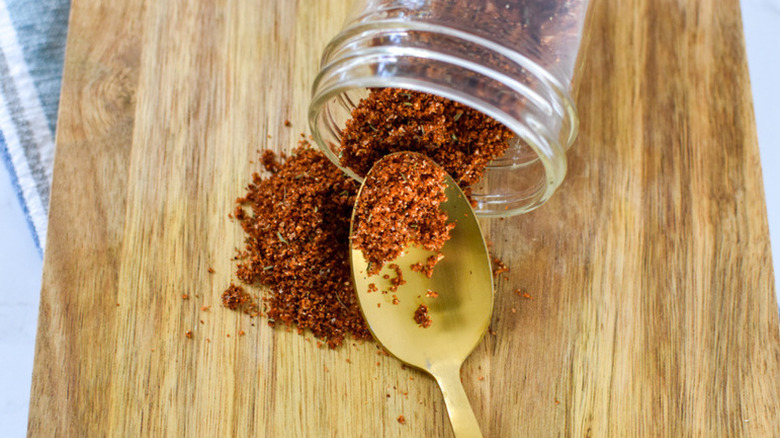Spicy rib seasoning spilling from glass spice jar