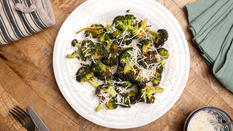 Parmesan-topped roasted broccoli on white plate