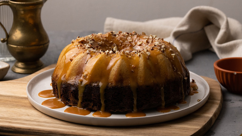 Layered chocolate flan topped with caramel sauce and chopped nuts