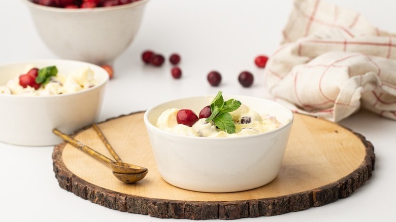 Cranberry fluff in white bowl with fresh cranberries
