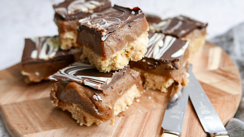 Stack of Millionaire's Shortbread slices on wooden board