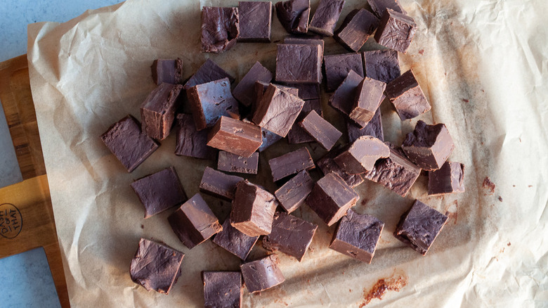 Pile of chocolate fudge squares on parchment paper