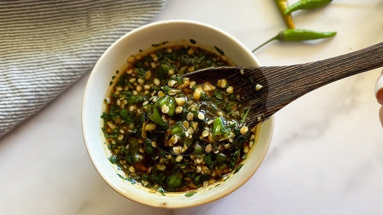 Bang bang sauce in small bowl with wooden spoon