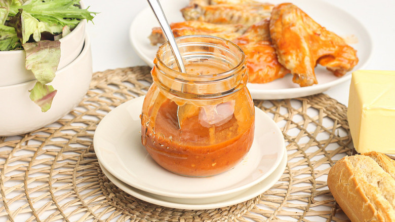 Buffalo wing sauce in glass jar with spoon